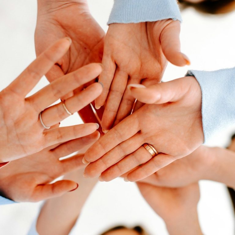 Mitarbeiter Verschiedene Hände, die übereinander gelegt sind, symbolisieren Zusammenarbeit und Gemeinschaft.